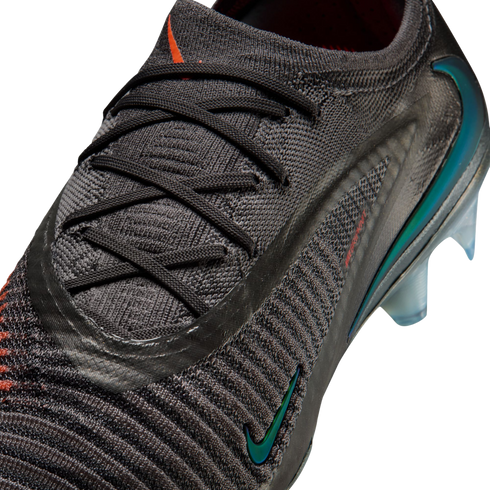 Close-up of a dark grey Nike soccer cleat with a textured knit upper, black laces, and an iridescent Nike swoosh on the side.