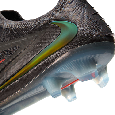Close-up of a black Nike soccer cleat with an iridescent green swoosh, textured upper, and translucent blue sole with clear studs.