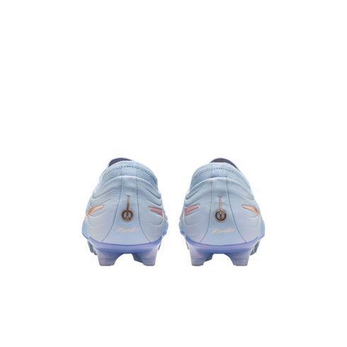 Rear view of light blue soccer cleats with gold "Maestro" logos on the heels, set against a solid black background.