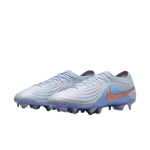 A pair of light blue Nike Tiempo soccer cleats with a metallic rose gold swoosh logo, positioned against a solid black background.