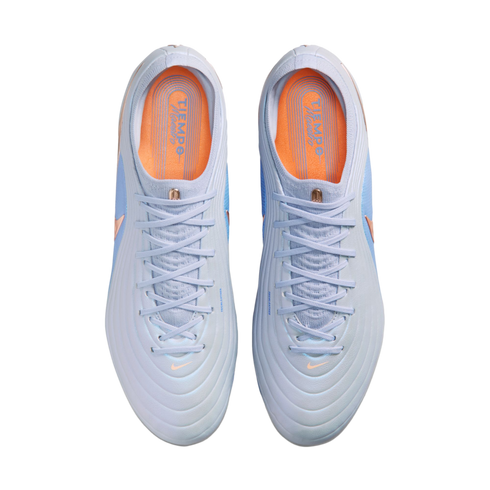 Top-down view of a pair of light blue Nike Tiempo soccer cleats with orange insoles, set against a solid black background.