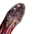 Underside of a metallic maroon Nike soccer cleat showing a pearlescent soleplate with clear studs, a yellow swoosh, and "Crafted for Brilliance" text.