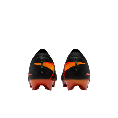 Rear view of black Nike Mercurial soccer cleats featuring orange and red accents on the heels and soleplates, set against a solid black background.