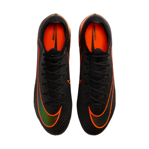 Top-down view of a pair of black Nike Mercurial soccer cleats with orange accents and iridescent Nike swooshes.