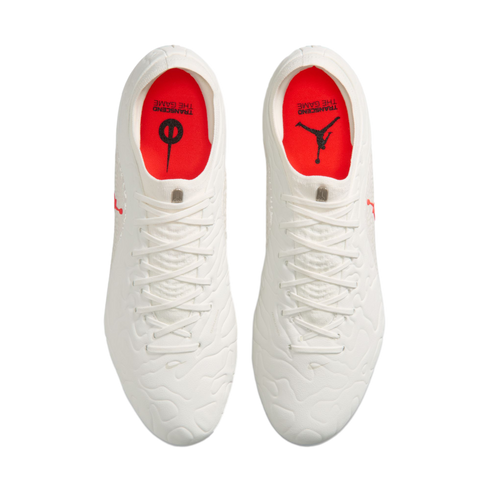 Top-down view of white soccer cleats with red insoles featuring Jumpman and Nike logos, isolated on a white background.
