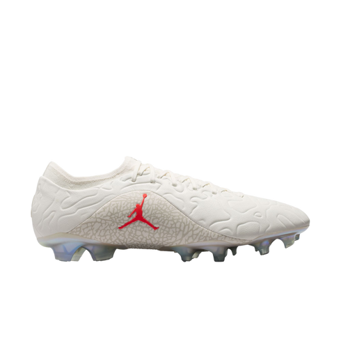 Side view of an off-white Jordan soccer cleat with a red Jumpman logo on a grey patterned midfoot and translucent studs.