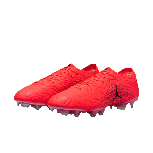 A pair of vibrant red Jordan soccer cleats featuring a textured upper and a black Jumpman logo, shown against a solid black background.