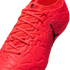 Close-up of a bright red soccer cleat with matching laces, a textured upper, and a black Jumpman logo on the side against a black background.