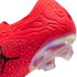 Close-up of a red Jordan soccer cleat heel featuring textured patterns, a black Jumpman logo, and a translucent, iridescent soleplate.