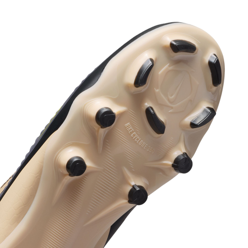 Close-up of a beige Nike soccer cleat's outsole with black studs and "NIKE CYCLONE 360" branding, shown against a solid black background.