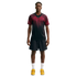 Full-body shot of a man wearing a black and maroon patterned athletic t-shirt, black shorts, white socks, and yellow sneakers, standing against a white background.