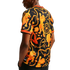 Back view of a person wearing a black t-shirt with an ornate orange pattern of lions, chains, and tulips against a white background.