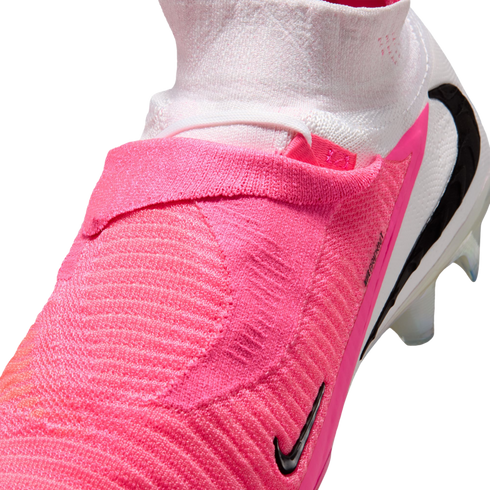 Close-up of a pink and white Nike soccer cleat featuring a textured upper and a high-top sock-like collar.