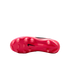 Bottom view of a pink Nike soccer cleat, featuring several rounded studs and a black Nike swoosh logo in the center.