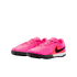 A pair of vibrant pink Nike turf soccer shoes with a black swoosh and textured upper, set against a plain white background.