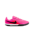 Bright pink Nike turf soccer shoe with a black swoosh, red accents, and wavy textured upper. Features a white midsole and black studded outsole.