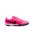 A vibrant pink and neon red Nike soccer shoe for artificial turf with a black Nike swoosh on the side and a black rubber outsole on a plain white background.