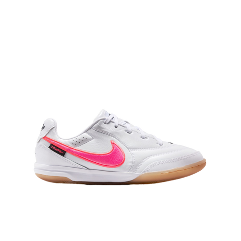 White Nike Tiempo indoor soccer shoe with a vibrant pink swoosh and a gum rubber outsole, shown in profile view against a white background.