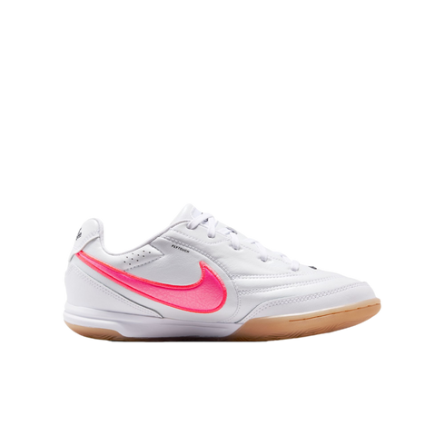 White Nike indoor soccer shoe with a textured bright pink swoosh and a tan gum rubber sole, shown on a white background.