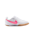 White Nike indoor soccer shoe with a textured bright pink swoosh and a tan gum rubber sole, shown on a white background.