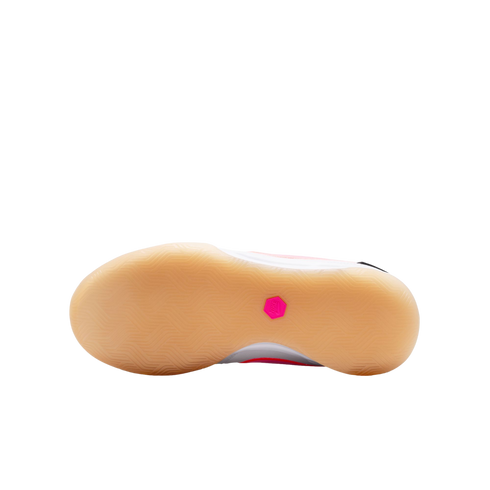 Bottom view of a Nike shoe featuring a tan gum rubber outsole with a textured tread and a small pink hexagonal logo in the center.