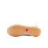Bottom view of a Nike shoe featuring a tan gum rubber outsole with a textured tread and a small pink hexagonal logo in the center.