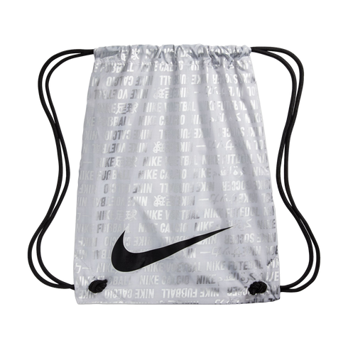 A silver Nike drawstring bag with a repeated multilingual soccer pattern and a large black swoosh logo on the front.