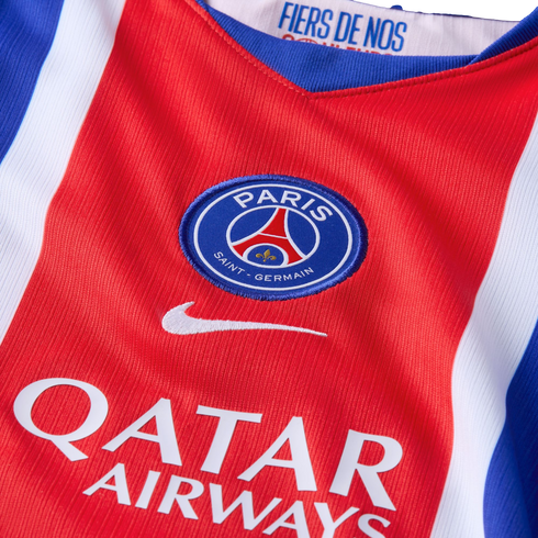 Close-up of a red Paris Saint-Germain jersey featuring the club crest, Nike logo, and Qatar Airways sponsor. Blue and white stripes line the sides.