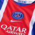 Close-up of a red Paris Saint-Germain jersey featuring the club crest, Nike logo, and Qatar Airways sponsor. Blue and white stripes line the sides.