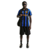 A Black man models an Inter Milan soccer jersey, black shorts, and sunglasses, carrying a black tote bag against a white background.
