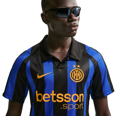 A man wearing an Inter Milan blue and black striped football jersey and dark sunglasses against a white background.