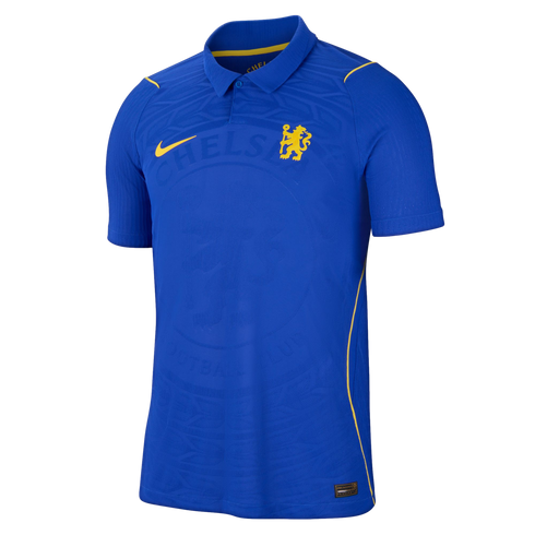 A blue Chelsea FC soccer jersey by Nike. Features a yellow swoosh and lion crest, a polo collar, and a tonal embossed pattern on the blue fabric.
