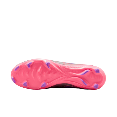 Underside of a pink soccer cleat with purple studs on a black background.