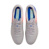 Top-down view of a pair of light grey Nike soccer cleats with pink and purple accents and blue insoles, centered against a solid black background.