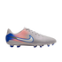 Side view of a light gray Nike soccer cleat with a pink and blue gradient heel, a white swoosh with blue trim, and blue studs, against a black background.