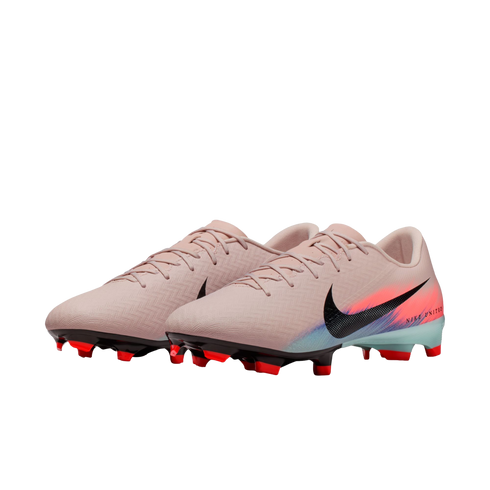 Pair of light pink Nike soccer cleats with a black swoosh, orange and teal accents, and red studs on a black background.