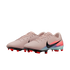 Pair of light pink Nike soccer cleats with a black swoosh, orange and teal accents, and red studs on a black background.