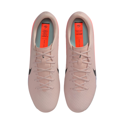 Top-down view of light pink Nike Mercurial soccer cleats with black swooshes and orange insoles, set against a black background.