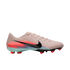 Side-view of a Nike soccer cleat in light pink with a black Swoosh and vibrant orange and blue graphic accents, set against a solid black background.