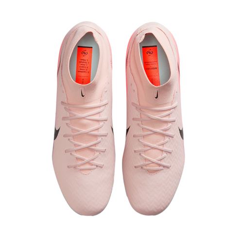 Top-down view of light pink Nike soccer cleats with matching laces and orange insoles on a black background.