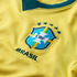 Close-up of a yellow Brazil national team soccer jersey featuring the embroidered CBF crest and five stars.