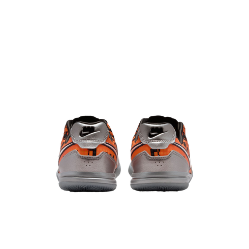 Rear view of a pair of orange and silver Nike athletic shoes with black accents on a white background.