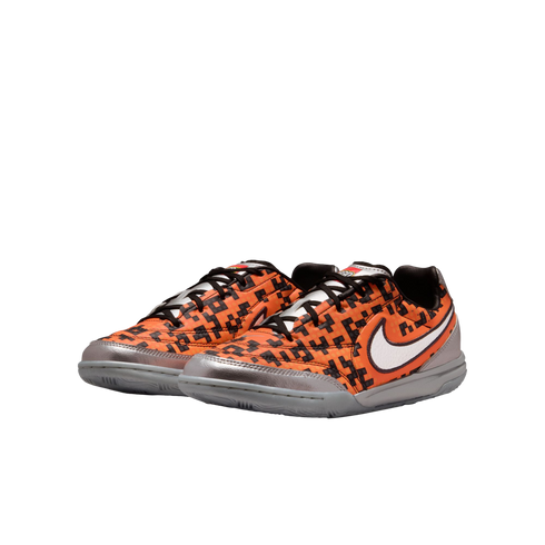 A pair of orange and black pixelated Nike sneakers with silver metallic accents, a white swoosh, and grey soles.