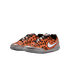 A pair of orange and black pixelated Nike sneakers with silver metallic accents, a white swoosh, and grey soles.