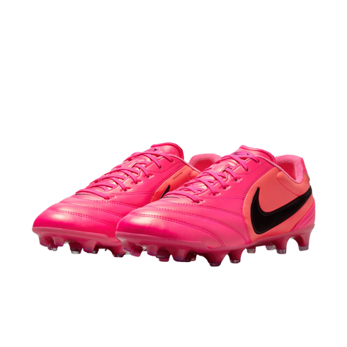A pair of vibrant pink Nike soccer cleats with black swoosh logos, shown against a white background.