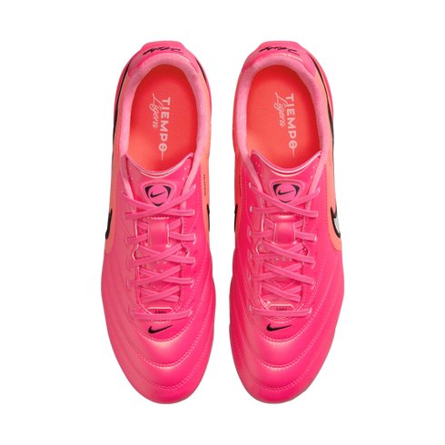 Top-down view of a pair of vibrant pink Nike Tiempo Ligera soccer shoes with pink laces and black Nike swoosh logos on a white background.