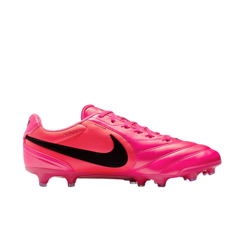 A side-profile view of a bright pink Nike soccer cleat with a large black swoosh on the side, pink laces, and pink studs.