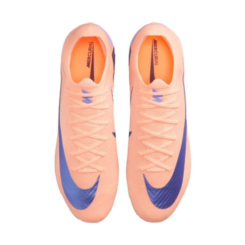 Top-down view of a pair of bright peach Nike Mercurial soccer cleats with large purple swooshes, displayed against a solid black background.