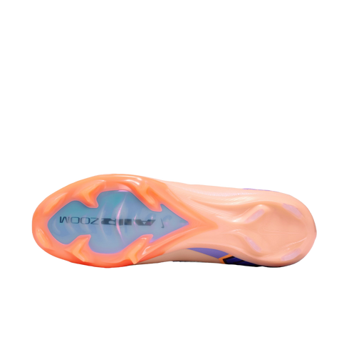 Bottom view of a peach and purple Nike soccer cleat featuring an iridescent blue "AIR ZOOM" forefoot plate and traction studs against a black background.