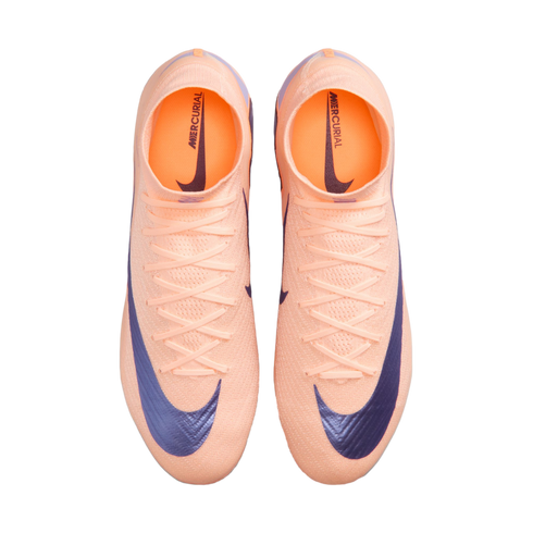 Top-down view of peach-colored Nike Mercurial soccer cleats with dark blue swooshes and high-top collars against a black background.